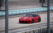 Спортивный красный Ferrari 599 подъезжает к линии старта на треке